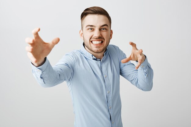 Homme d'affaires ennuyé regarde en colère, tendant la main pour étrangler quelqu'un