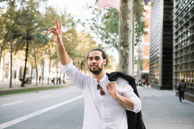 Photo gratuite homme d'affaires essayant de héler un taxi dans la rue