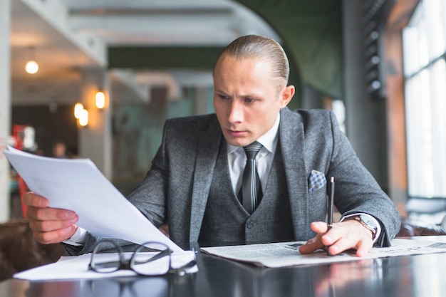 Homme d&#39;affaires examinant un document dans un café