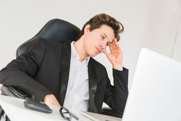 Photo gratuite homme d'affaires fatigué, assis dans le bureau