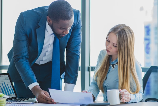 Homme d&#39;affaires et femme d&#39;affaires vérifiant un document