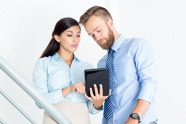 Homme d&#39;affaires et femme utilisant la tablette sur les escaliers