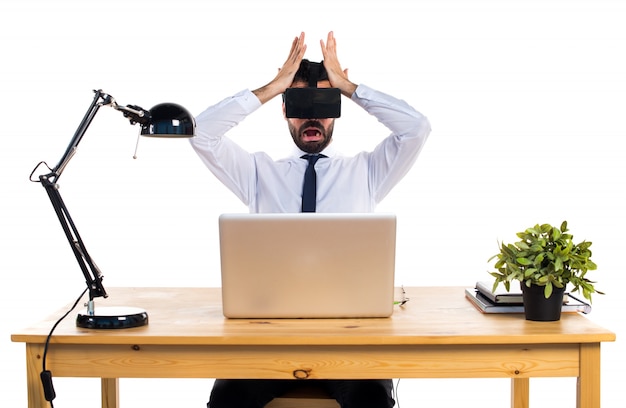 Homme d&#39;affaires frustré dans son bureau en utilisant des lunettes VR