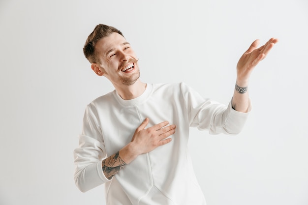 Homme d'affaires heureux debout, souriant isolé sur studio gris