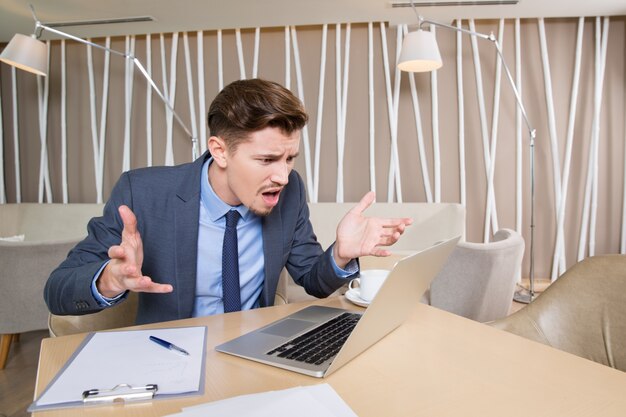 Homme d&#39;affaires Indigné de travail sur ordinateur portable dans le café