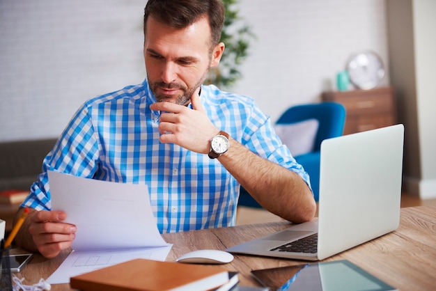 Homme d'affaires lisant des documents importants à son bureau