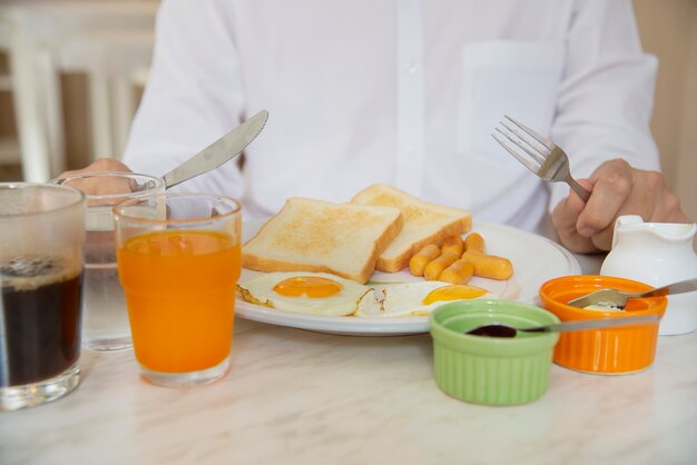 Homme d&#39;affaires mange le petit déjeuner américain dans un hôtel