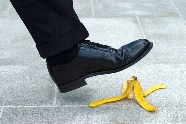 Homme d&#39;affaires marcher sur la peau de banane