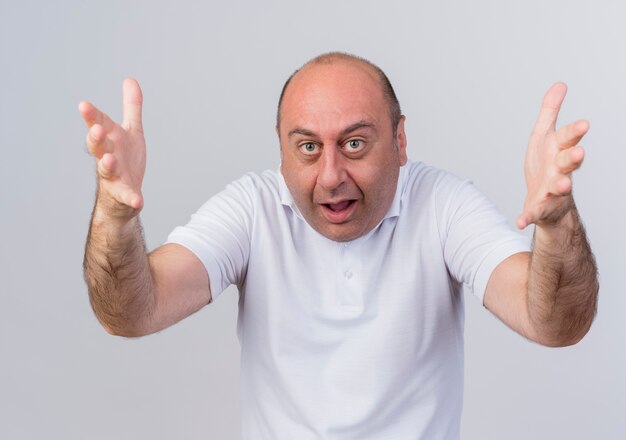 Homme d'affaires mature occasionnel impressionné regardant la caméra et étirant les mains vers la caméra isolée sur fond blanc