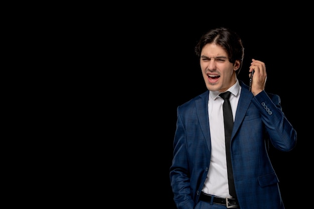 Homme d'affaires mignon beau mec en costume bleu foncé avec la cravate criant au téléphone