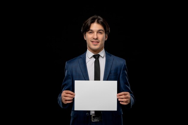 Homme d'affaires mignon gars charismatique en costume bleu foncé avec la cravate montrant la feuille de papier