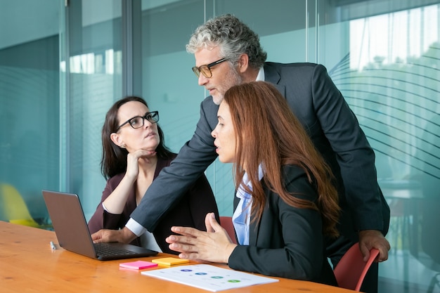 Homme d'affaires montrant la présentation sur PC aux employés.