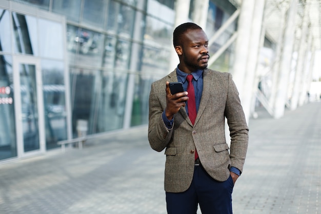 Homme d&#39;affaires noir élégant afro-américain travaille sur son smartphone