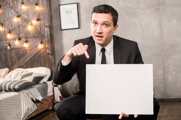 Homme d&#39;affaires avec papier vide, assis sur une chaise