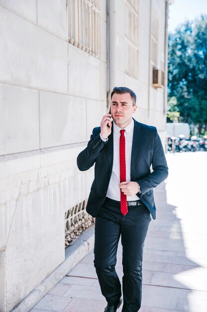 Homme d&#39;affaires, parlant au téléphone sur la rue
