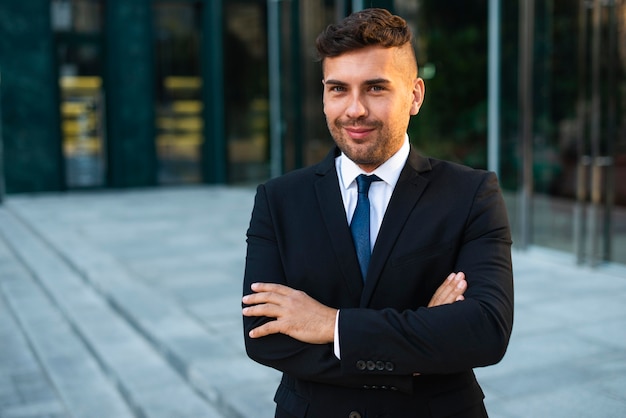 Homme d'affaires en plein air ayant les bras croisés