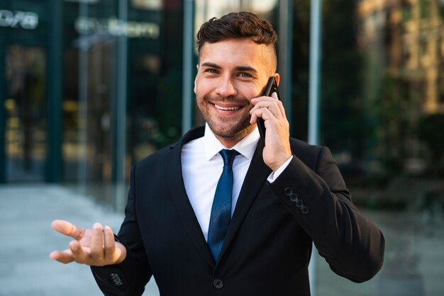 Homme d'affaires en plein air, parler au téléphone avec un client