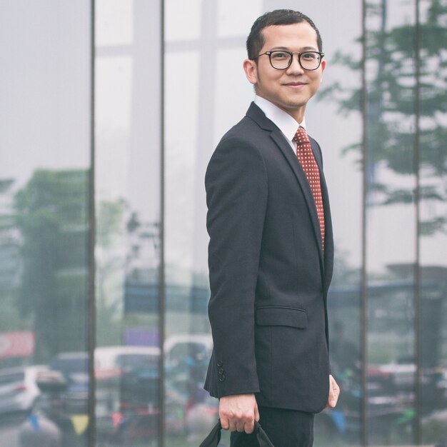 L&#39;homme d&#39;affaires portait son ordinateur portable devant l&#39;immeuble de bureaux