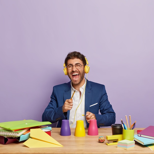 Photo gratuite homme d'affaires positif assis au bureau