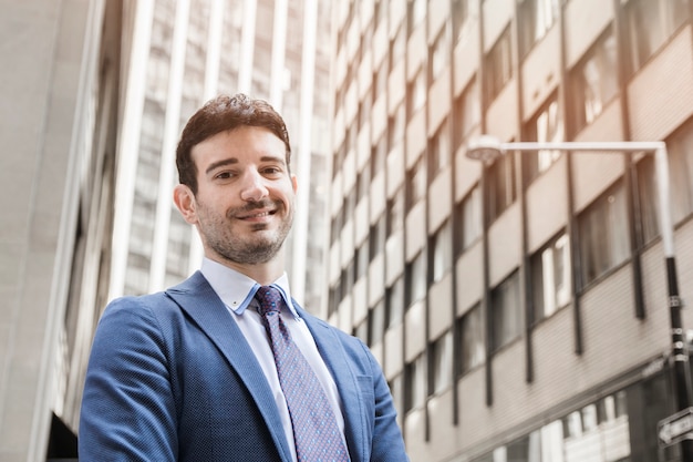 Homme d&#39;affaires positif debout dans la rue