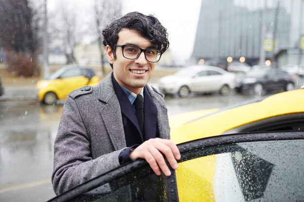 Homme d'affaires prenant un taxi sous la pluie