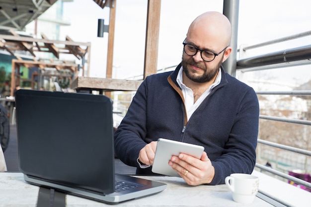 Homme d&#39;affaires prospère continue de travailler pendant la pause café