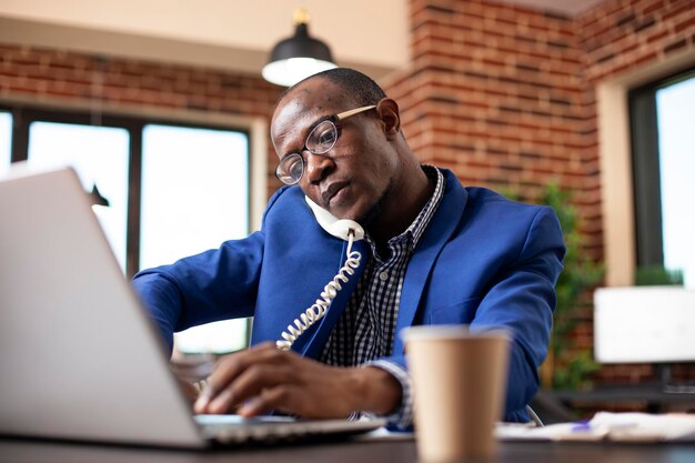 Homme d'affaires qui traite des appels téléphoniques au travail