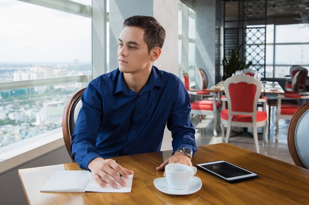 Homme d&#39;affaires regardant par la fenêtre de travail Alors que