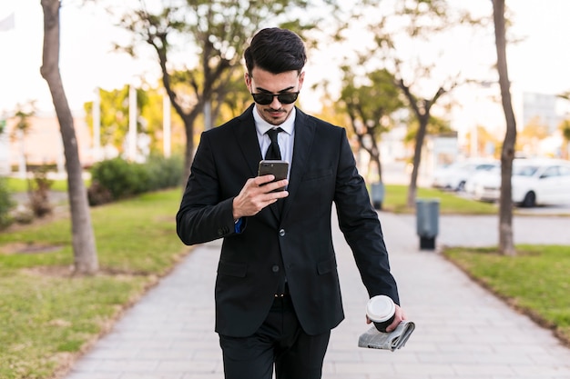 Homme d&#39;affaires en regardant son téléphone dans le parc