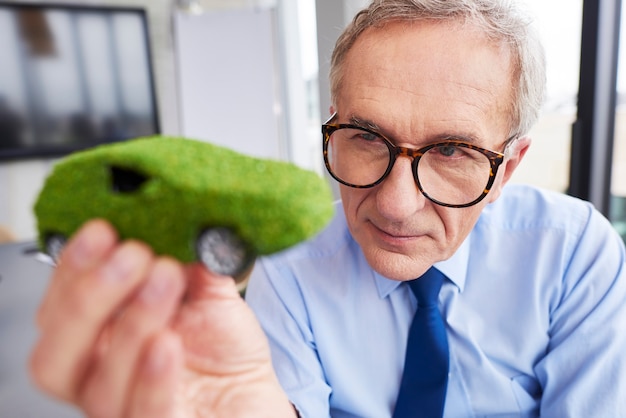 Photo gratuite homme d'affaires regardant une voiture écologique