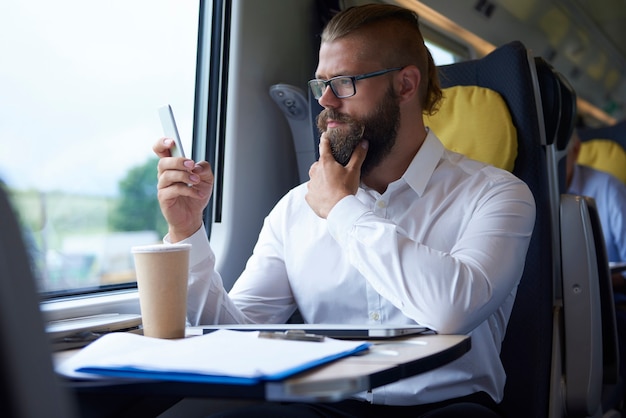 Homme affaires, regarder, téléphone portable