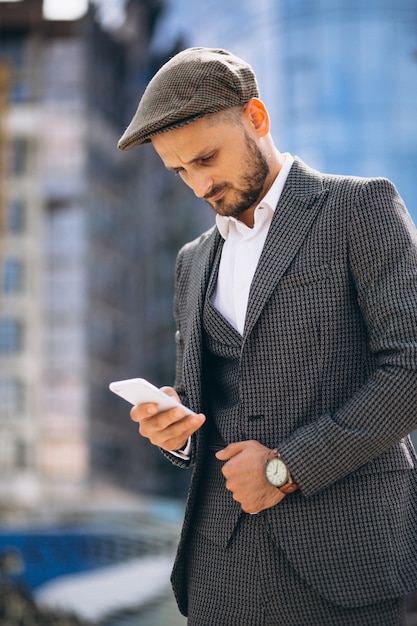 Homme d&#39;affaires réussi par le gratte-ciel parlant au téléphone