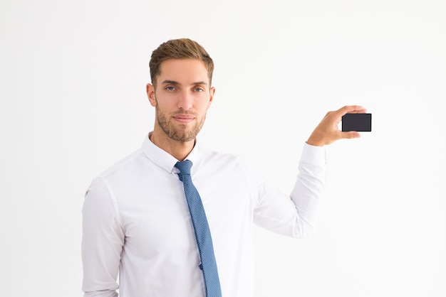 Homme d&#39;affaires sérieux montrant la carte de visite vierge