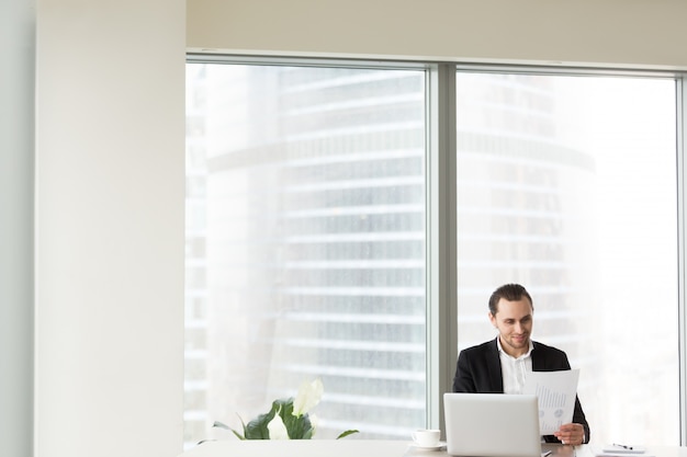 Photo gratuite homme d'affaires souriant au bureau