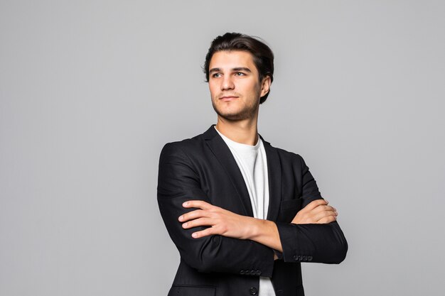 Homme d'affaires souriant debout avec les bras croisés isolé sur un blanc