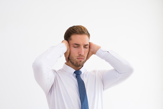 Homme d&#39;affaires stressé couvrant les oreilles avec les mains