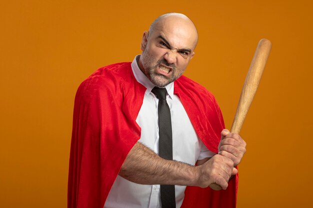 Homme d'affaires de super héros en cape rouge balançant une batte de baseball avec une expression agressive en colère