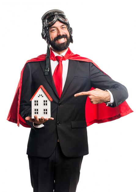 Homme d&#39;affaires super héros tenant une petite maison
