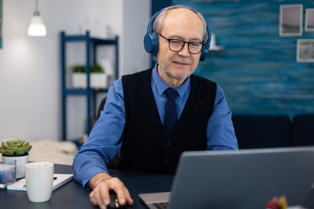 Homme d'affaires supérieur écoutant de la musique avec des écouteurs