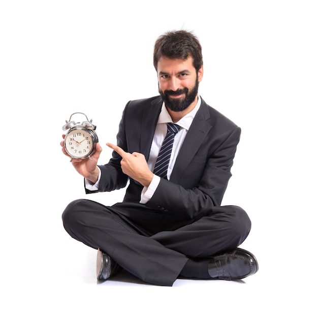 Homme d&#39;affaires tenant une horloge sur fond blanc