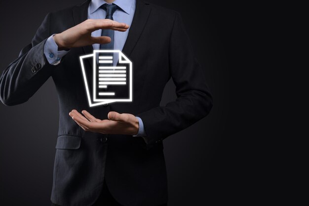 Homme d'affaires tenant une icône de document dans sa main concept de technologie internet d'entreprise de système de données de gestion de documents. système de gestion des données d'entreprise dms