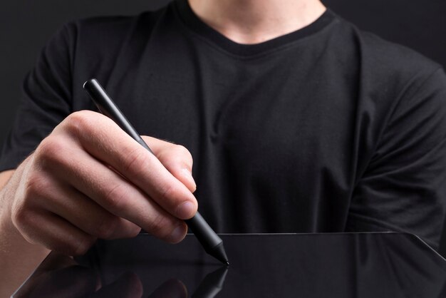 Homme d'affaires tenant une tablette et écrivant un écran invisible avec une couverture de médias sociaux de stylet
