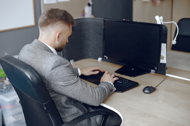 Homme d'affaires travaillant au bureau L'homme utilise un ordinateur. Guy est assis au bureau