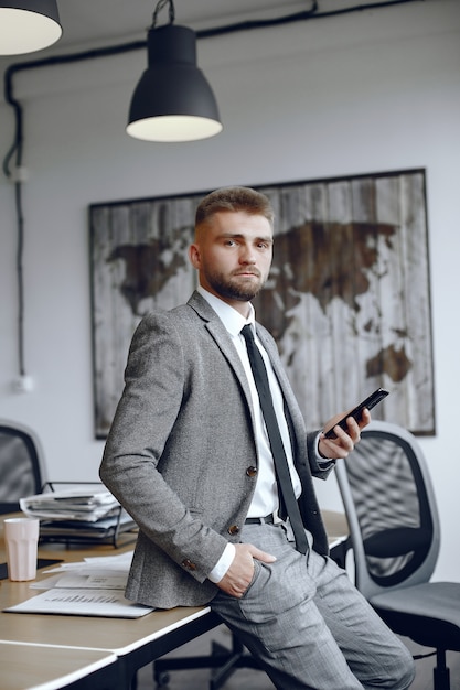 Homme d'affaires travaillant au bureau L'homme utilise le téléphone. Guy est assis au bureau