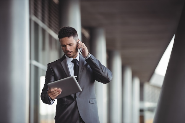 Homme affaires, utilisation, tablette numérique, quoique, conversation téléphone mobile