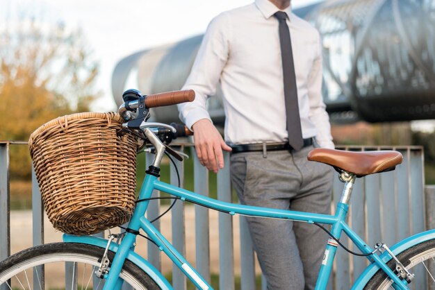 Homme d'affaires avec vélo vintage au bord de la rivière