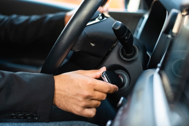 Homme d'affaires vue latérale démarrer la voiture