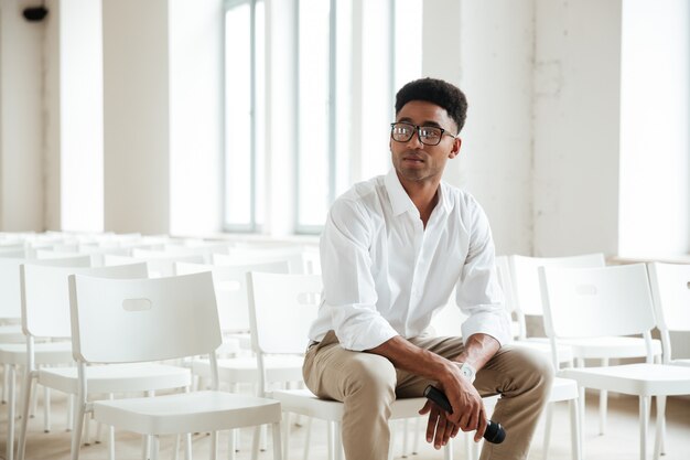 Homme africain concentré assis dans le bureau à l'intérieur