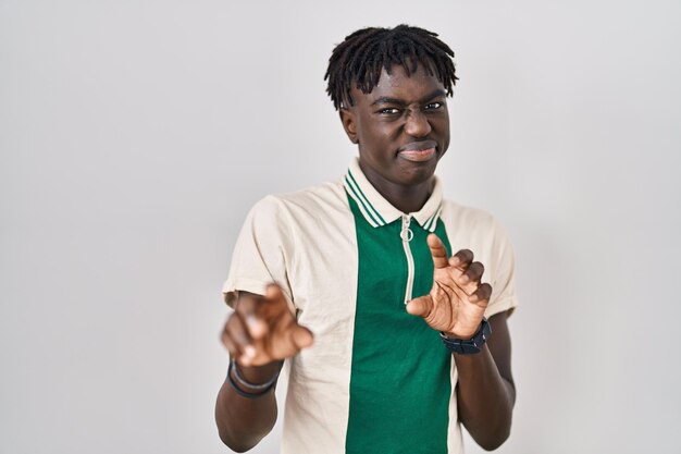 Homme africain avec des dreadlocks debout sur fond isolé expression dégoûtée mécontent et craintif faisant face au dégoût parce que la réaction d'aversion