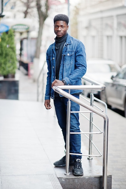 L'homme africain porte une veste en jean posée en plein air